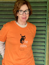 Stephanie wearing our brand new 2026 headless horseman "he rides" design orange tee shirt